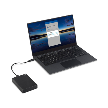 Laptop connected to an external hard drive on a white background