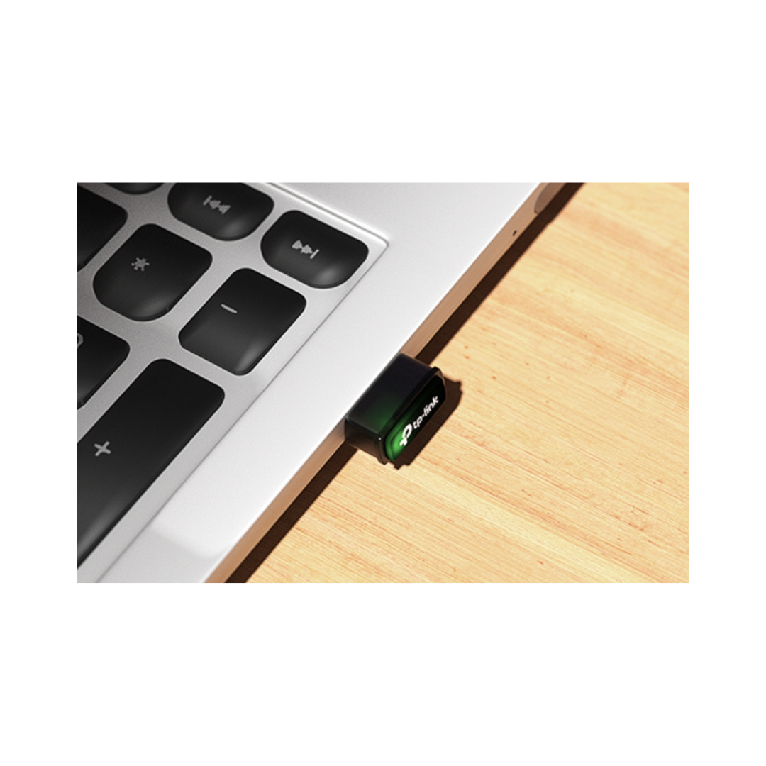 USB drive attached to a laptop on a wooden surface